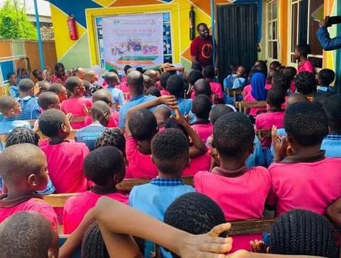 Pupils in pink uniforms gathered at the Read for a Smile literacy project